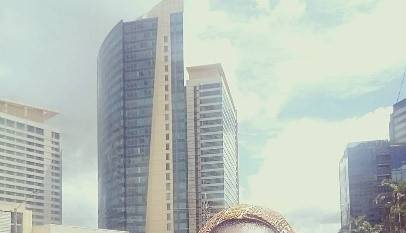 Black woman in blue top and head wrap in downtown city