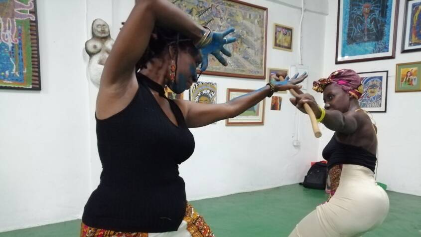 Two black women squaring off against each other in the African traditional stickfighting style, Kalinda